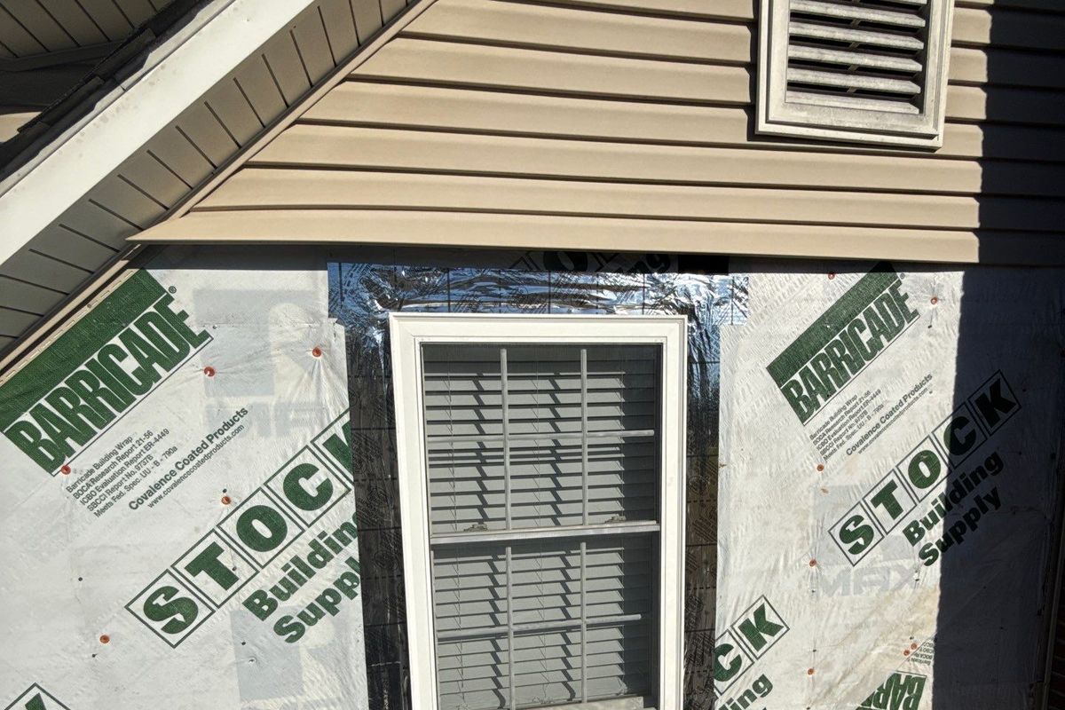 New lap siding being installed around windows on a home exterior